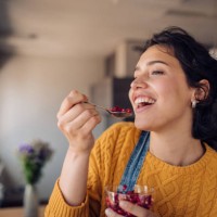 portrait of a happy girl enjoying fresh pomegranate at home - food stock pictures, royalty-free photos & images