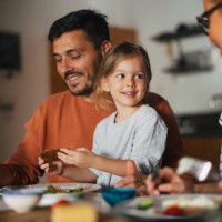 portrait of a happy little girl having breakfast with her mother and father at home - food stock pictures, royalty-free photos & images