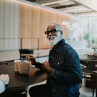 portrait of a happy man enjoying a takeaway lunch in a commercial setting - junk food stock pictures, royalty-free photos & images