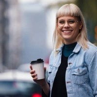portrait of a happy young woman outdoor holding a paper cup to go - junk food stock pictures, royalty-free photos & images