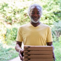 portrait of a senior deliveryman delivering pizza - junk food stock pictures, royalty-free photos & images
