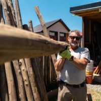 portrait of a senior man working holding a tree trunk in a house garden - home decoration stock pictures, royalty-free photos & images