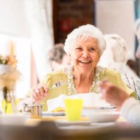 portrait of a smiling senior woman having lunch with friends - food stock pictures, royalty-free photos & images