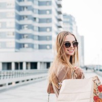 portrait of a smiling woman carrying shopping bags - fashion stock pictures, royalty-free photos & images