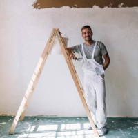 portrait of a smiling young man plastering wall in his workshop - home decoration stock pictures, royalty-free photos & images