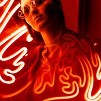 portrait of a woman in glasses against red neon sign - fashion stock pictures, royalty-free photos & images