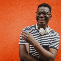 portrait of a young african-american man in front of the orange wall - fashion stock pictures, royalty-free photos & images