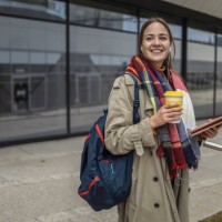 portrait of a young female university student smiling while drinking coffee and using tablet - junk food stock pictures, royalty-free photos & images