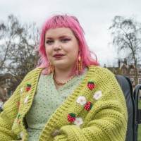 portrait of a young non-binary person with colourful hair sitting in an electric wheelchair - fashion stock pictures, royalty-free photos & images