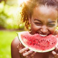 portrait of a young woman eating watermelon on a sunny day, backlit - food stock pictures, royalty-free photos & images