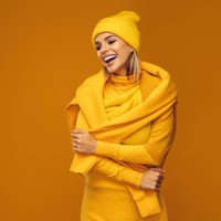 portrait of a young woman wearing yellow sweater and hat - fashion stock pictures, royalty-free photos & images