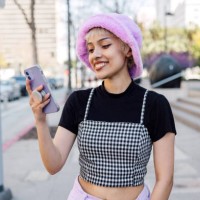portrait of a young woman with her mobile phone texting and scrolling social media in the streets - fashion stock pictures, royalty-free photos & images