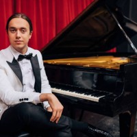 portrait of an elegant young pianist sitting by the piano ready to perform - concert stock pictures, royalty-free photos & images
