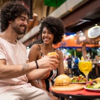 portrait of beautiful tourists couple eating traditional food in the municipal market - food stock pictures, royalty-free photos & images