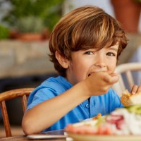 portrait of boy eating food at table in house - food stock pictures, royalty-free photos & images