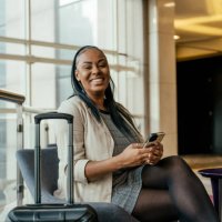 portrait of businesswoman in hotel lobby holding smartphone - travel stockfoto's en -beelden