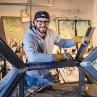portrait of caucasian man leaning on metal sculpture - home decoration stock pictures, royalty-free photos & images