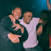 portrait of cheerful young man dancing with male friend at nightclub - concert stock pictures, royalty-free photos & images
