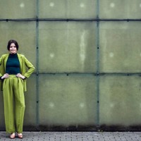 portrait of confident businesswoman wearing green suit standing at a wall - fashion stock pictures, royalty-free photos & images