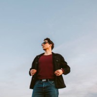 portrait of confident young man standing against blue sky - fashion stock pictures, royalty-free photos & images