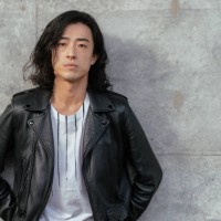 portrait of cool young handsome man wearing leather jacket and leaning against concrete wall - fashion stock pictures, royalty-free photos & images