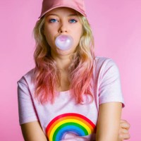 portrait of cool young woman with bubble gum in front of pink background - fashion stock pictures, royalty-free photos & images