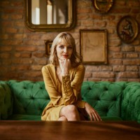 portrait of elegant woman sitting on a couch - fashion stock-fotos und bilder