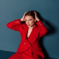 portrait of fashionable woman in red jacket sitting looking at camera. concept fashion - fashion stock pictures, royalty-free photos & images