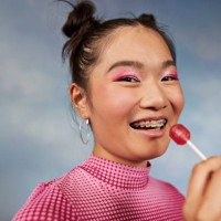 portrait of happy teenage girl having lollipop against colored background - food stock pictures, royalty-free photos & images