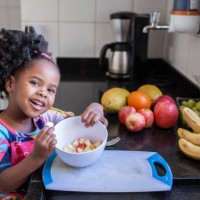 portrait of little girl eating fruits in the kitchen - food stock pictures, royalty-free photos & images
