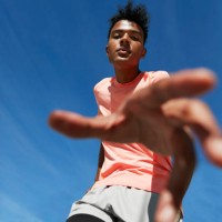 portrait of male athlete gesturing against blue sky - fashion stock-fotos und bilder