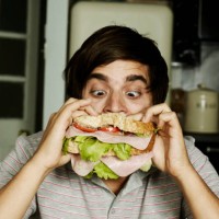 portrait of man eating sandwich - food stock-fotos und bilder
