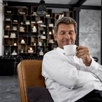 portrait of mature man enjoying cup of coffee in loft - coffee stockfoto's en -beelden