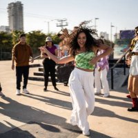 portrait of mid adult woman dancing reggaeton during street party with her friends outdoors - concert stock pictures, royalty-free photos & images