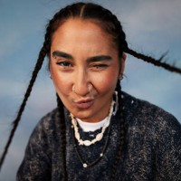 portrait of non-binary person with braided hair puckering against colored background - fashion stock pictures, royalty-free photos & images