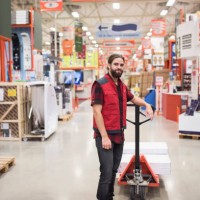 portrait of salesman standing by handtruck in hardware store - home decoration stock pictures, royalty-free photos & images