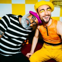 portrait of senior man with head on young male friend's shoulder in living room - fashion photos et images de collection