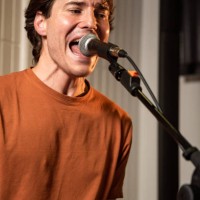 portrait of singer singing at a concert in a pub with colored light illumination - concert stock pictures, royalty-free photos & images