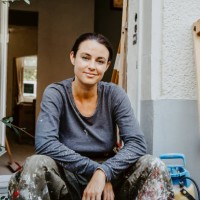 portrait of smiling female carpenter sitting in front of house entrance - home decoration stock-fotos und bilder