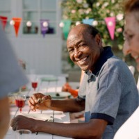 portrait of smiling senior man sitting with woman at dining table in back yard - garden decoration photos et images de collection