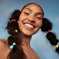 portrait of smiling teenage girl with braided hair against colored background - fashion stock pictures, royalty-free photos & images