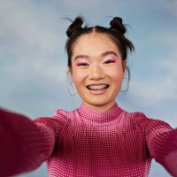 portrait of smiling teenage girl with pigtails taking selfie against colored background - fashion fotografías e imágenes de stock