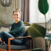 portrait of smiling woman sitting on armchair at home - home decoration stock pictures, royalty-free photos & images