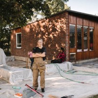 portrait of smiling woman with crossed arms standing against house - home decoration stock pictures, royalty-free photos & images