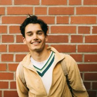 portrait of smiling young man against brick wall - fashion stock pictures, royalty-free photos & images