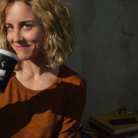 portrait of smiling young woman drinking coffee to go at home - junk food stock pictures, royalty-free photos & images
