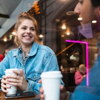 portrait of smiling young woman in a coffee shop looking at young man - junk food stock pictures, royalty-free photos & images