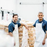 portrait of two happy butchers working at meat packaging warehouse - food stock pictures, royalty-free photos & images