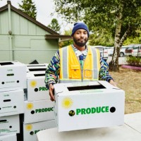 portrait of volunteer at community center giving away csa boxes - food stock pictures, royalty-free photos & images