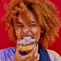 portrait of woman eating a donut - food stock pictures, royalty-free photos & images
